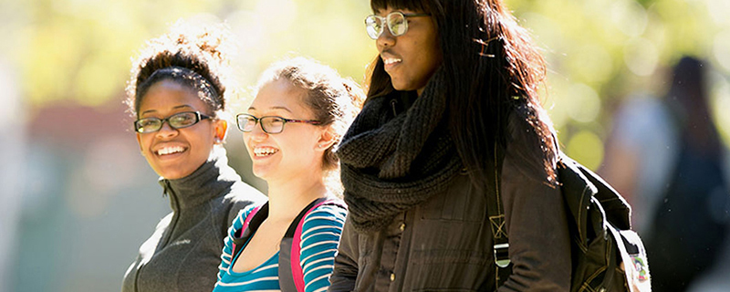 3 students walking together on the Illinois State University quad.